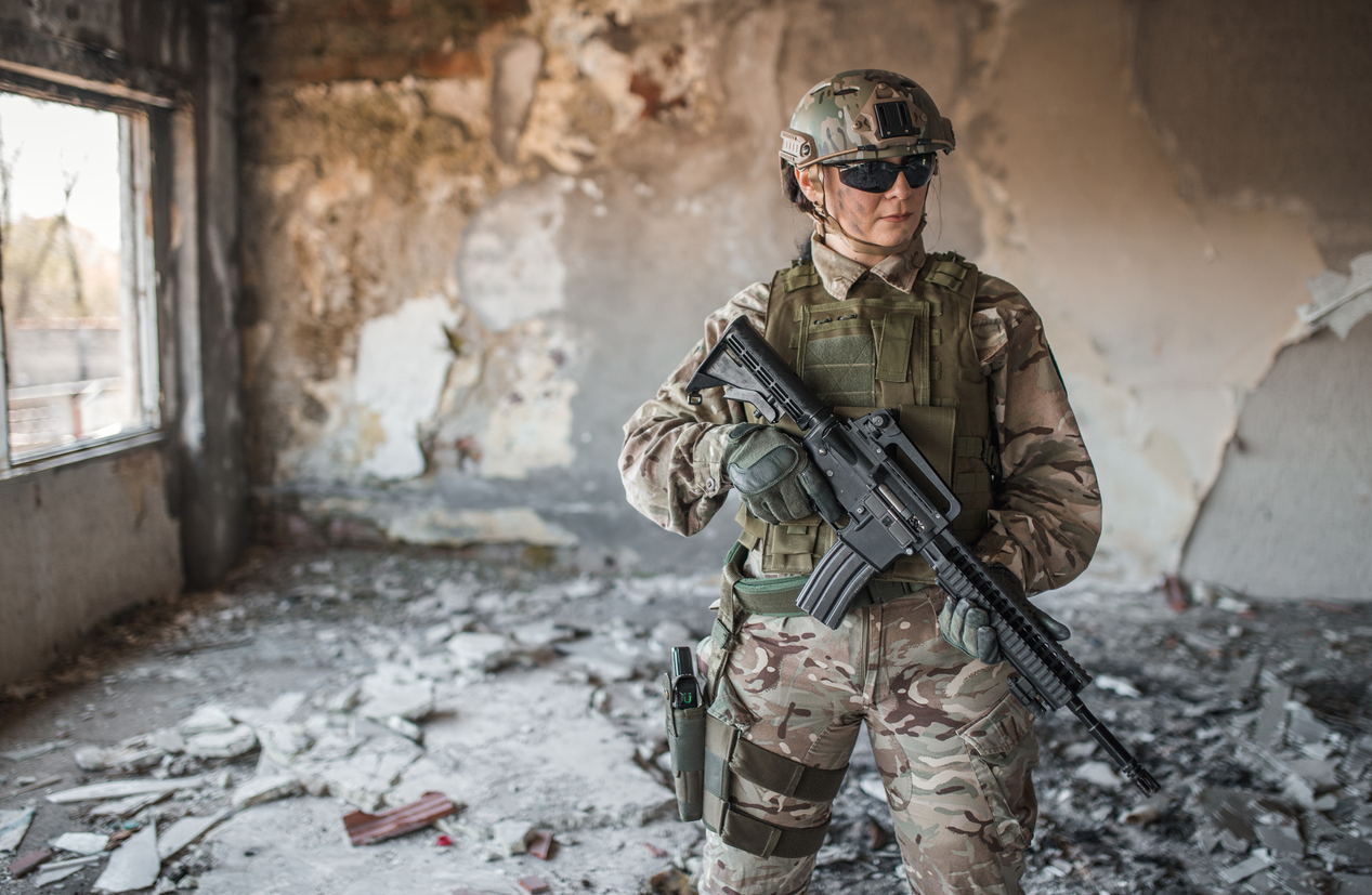 Special forces woman soldier with rifle in abandoned warehouse