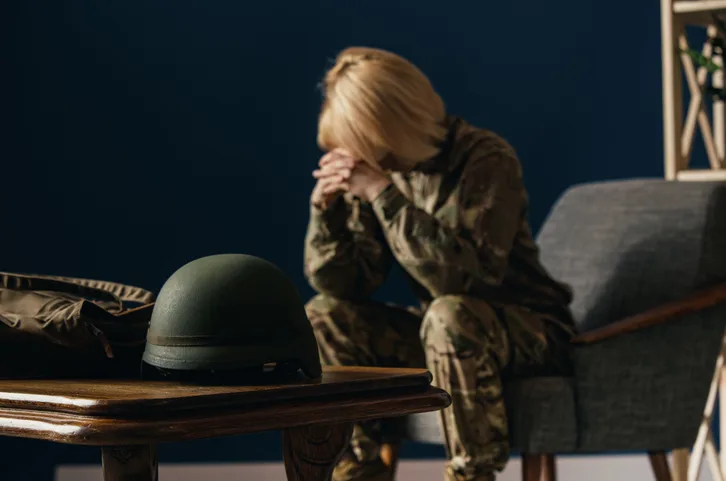 Woman in military uniform on the war. In doctor's consultation, depressed and having problems with mental health