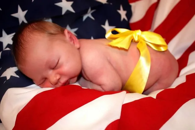 baby with a yellow ribbon around him