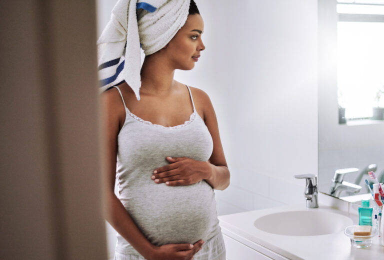 Shot of a pregnant young woman standing in the bathroom at home