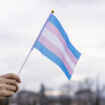 Transgender Flag being held in the sky