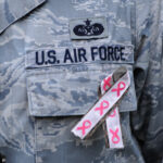 A U.S. airman wears a pink ribbon in support of the Dilorenzo Clinic's Breast Cancer Awareness Walk/Run event in the Pentagon's center courtyard, Washington, D.C., Oct. 24, 2013. Department of Defense civilians and service members and breast cancer survivors participated in the walk to raise awareness for breast cancer. (U.S. Army photo by Eboni Everson-Myart/Released)