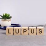 wooden block form the word Lupus with stethoscope on the doctor's desktop